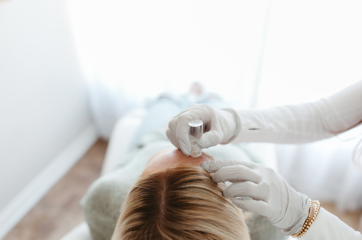 Nurse performing microinfusion treatment on forehead at Nuud Skin Co. 